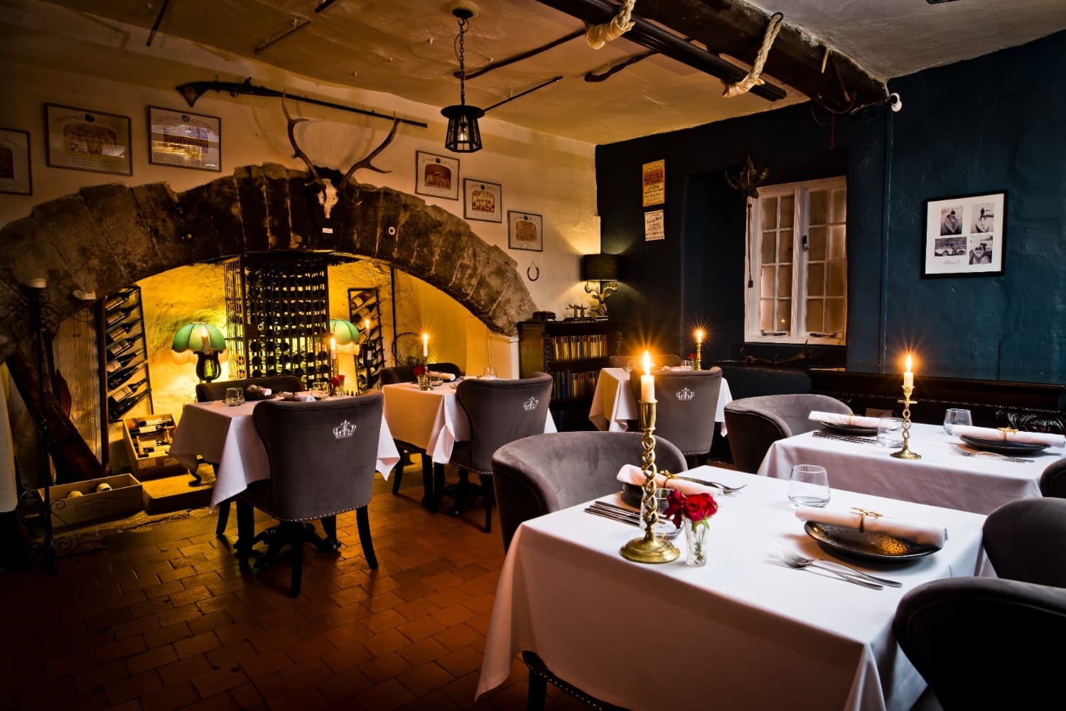 The candlelit dining room at Plas Dinas, set under a stone cellar arch